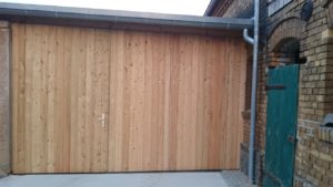 Holz-Garagenholztor mit verdeckter Mehrfachklappung aus Lärchenholz